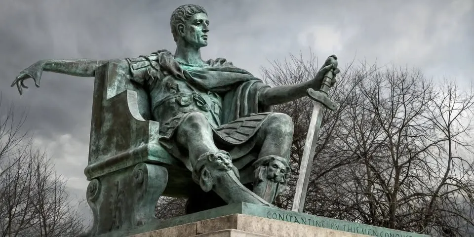 Bronze statue of Emperor Constantine seated beneath a stormy sky